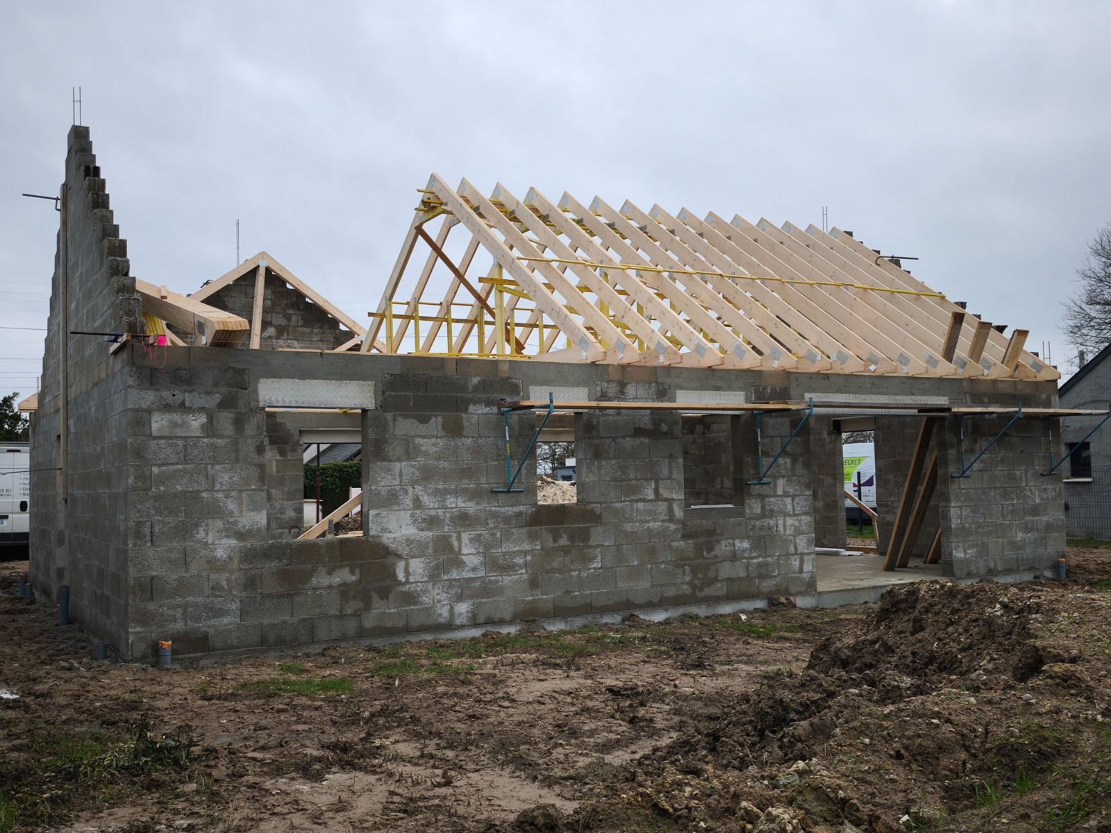Charpente en bois en cours de pose sur un bâtiment maçonné